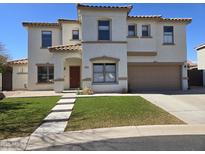 Beautiful two-story home featuring a well manicured lawn and desert landscaping at 9043 E Posada Ave, Mesa, AZ 85212