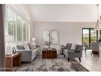 Bright living room with plantation shutters, neutral tones and a comfortable seating arrangement at 9812 E Karen Dr, Scottsdale, AZ 85260
