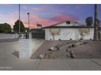 Charming single-Gathering home showcasing a white brick exterior with desert landscaping at 1716 W Butler Dr, Phoenix, AZ 85021