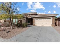 Charming single-story home with a well-manicured front yard, mature tree, and a spacious three car driveway at 31660 N 130Th Ln, Peoria, AZ 85383