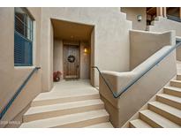 Inviting front entrance with decorative wooden door, wreath, and steps leading to the home at 36601 N Mule Train Rd # 40A, Carefree, AZ 85377