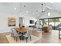 Bright open floor plan with dining table and living room featuring modern decor and hardwood floors at 6305 N 10Th Dr, Phoenix, AZ 85013
