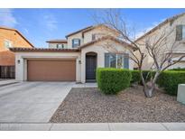 Charming two-story home featuring a brown two car garage, well-kept lawn, and desert rock landscaping at 7949 E Boise St, Mesa, AZ 85207
