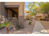 Exterior view of condo building with courtyard, walkway, and desert landscaping at 10136 E Southern Ave # 1082, Mesa, AZ 85209