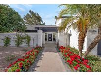 Inviting home entrance with desert landscaping and a decorative pergola over a walkway to the front door at 10360 N 98Th St, Scottsdale, AZ 85258