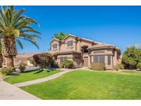 Charming two-story home with mature landscaping, lush green lawn, and a beautiful palm tree at 1446 E Oxford Ln, Gilbert, AZ 85295