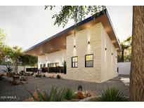 Modern home exterior with a stone accent wall, a black roofline and desert landscaping at 15674 S Overfield Rd, Arizona City, AZ 85123