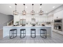 Modern kitchen with pendant lighting, stainless steel appliances, and a large island with seating at 240 W Missouri Ave # 13, Phoenix, AZ 85013