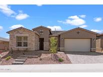 Charming single-story home featuring stone accents, a two-car garage, and a landscaped front yard at 32489 N 135Th Dr, Peoria, AZ 85383