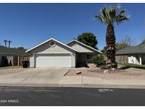 Charming single-Gathering home with a two-car garage, desert landscaping, and a mature palm tree at 614 W 7Th Ave, Mesa, AZ 85210