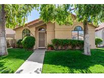 Charming single-story home featuring lush landscaping, a secure front door, and a well-manicured lawn at 855 E Vaughn Ave, Gilbert, AZ 85234