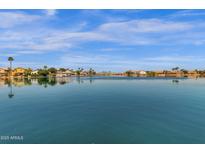 Scenic waterfront view showcases community lake and residential properties with palm trees, perfect for lakeside living at 9019 W Acoma Dr, Peoria, AZ 85381