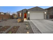 Charming single-story home with desert landscaping, a red door, and a two car garage at 9543 W Donald Dr, Peoria, AZ 85383