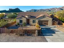 Beautiful home exterior with a tiled roof, desert landscaping, and striking mountain views at 10142 E La Palma Ave, Gold Canyon, AZ 85118