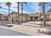 Charming single-story home featuring desert landscaping with elegant palm trees and a spacious driveway at 11844 N 146Th Ave, Surprise, AZ 85379