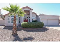 Charming single-story home with a well-manicured lawn, desert landscaping, and a vibrant red front door at 1915 E Citation Ln, Tempe, AZ 85284