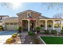 Charming single-story home with stone facade, covered porch, and well-maintained landscaping at 20421 W Legend Trl, Buckeye, AZ 85396