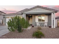 Inviting home exterior with rocking chairs on the front porch and a well-maintained yard at 28883 N 131St Dr, Peoria, AZ 85383