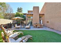 Inviting backyard with a patio, outdoor seating, a grill, and artificial grass, perfect for entertaining and relaxation at 4434 E Camelback Rd # 132, Phoenix, AZ 85018