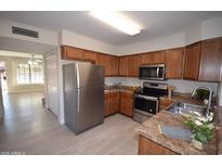 Well-lit kitchen features stainless steel appliances, wood cabinets and countertop space at 921 W University Dr # 1215, Mesa, AZ 85201