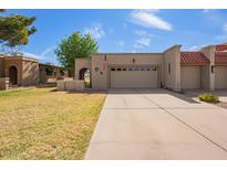 Charming home with a two-car garage, American flag, and desert landscaping at 10127 E Minnesota Ave, Sun Lakes, AZ 85248