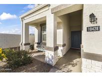 Charming front porch with stone accents, cozy bench, and inviting entryway to this home at 10428 S 54Th Ln, Laveen, AZ 85339