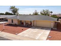 Charming home with a two-car garage, well-maintained yard, and cozy front porch seating area at 10511 W Edgewood Dr, Sun City, AZ 85351