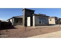 Charming single-story home with a stone archway entrance and low maintenance desert landscaping at 17312 W Royal Palm Rd, Waddell, AZ 85355