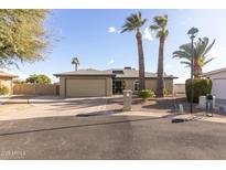 Charming single-story home with desert landscaping, palm trees, and attached two-car garage at 26649 S Howard Dr, Sun Lakes, AZ 85248