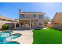 Stunning backyard featuring a sparkling pool, lush artificial turf, and covered patio perfect for outdoor entertaining at 4216 E Tether Trl, Phoenix, AZ 85050