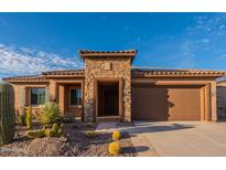 Charming single-story home with a stone facade and a well-manicured desert landscape at 8180 W Silver Spring Way, Florence, AZ 85132