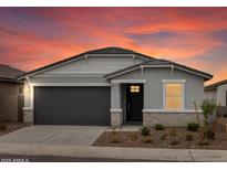 Charming single-story home with gray stucco, well-manicured landscaping and beautiful sunset backdrop at 8554 W Trenton Ct, Florence, AZ 85132