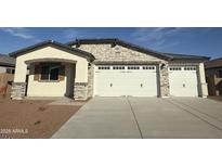 Charming exterior view of the house with a three-car garage and well-maintained desert landscaping at 8561 N 175Th Ln, Waddell, AZ 85355