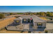 Charming single story home featuring immaculate desert landscaping and a grand entrance with an American flag at 21717 W South Mountain Ave, Buckeye, AZ 85326