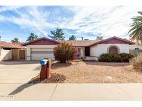 Charming single-story home featuring a two-car garage, desert landscaping, and a red brick accent at 5043 W Christy Dr, Glendale, AZ 85304