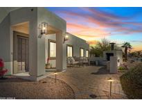 Charming outdoor space with brick pavers, outdoor fireplace, and seating, perfect for evening relaxation and entertaining at 6440 E Jean Dr, Scottsdale, AZ 85254