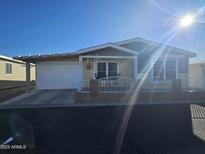 Charming single-story home with a carport and cozy front porch with white railing, perfect for enjoying the outdoors at 650 N Hawes Rd # 3827, Mesa, AZ 85207