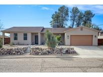 Charming single-story home featuring desert landscaping and an attached two-car garage at 725 W Hermosa Dr, Wickenburg, AZ 85390