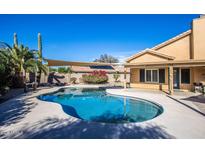 Backyard pool featuring a covered patio area, desert landscaping, and a clear blue sky at 7365 W Via Del Sol Dr, Glendale, AZ 85310