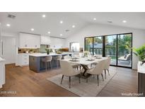 Bright dining room open to kitchen, with a large island, stainless appliances and hardwood floors at 743 E Sierra Vista Dr, Phoenix, AZ 85014