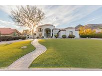 Stunning white home featuring pristine landscaping, a brick walkway, and manicured lawn at 11628 S Warcloud Ct, Phoenix, AZ 85044