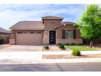 Charming single-story home showcasing a well-manicured front yard and inviting two-car garage at 20471 E Carriage Way, Queen Creek, AZ 85142