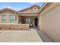 Charming home exterior boasts stone accents, covered porch, and inviting curb appeal, next to the garage at 337 S 172Nd Dr, Goodyear, AZ 85338