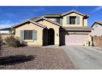 Charming two-story home featuring desert landscaping, a two-car garage, and a classic arched entryway at 22164 W Devin Dr, Buckeye, AZ 85326