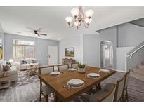 Bright, open-concept living room and dining area with hardwood floors and modern furnishings at 43608 W Kristal Ln, Maricopa, AZ 85138