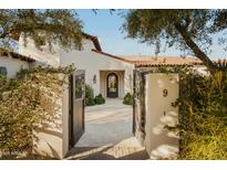Inviting entryway featuring a decorative iron door, with stone walkway and desert landscaping at 6640 E Kasba Cir, Paradise Valley, AZ 85253