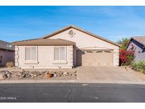 Charming single-story home featuring a two-car garage, neutral stucco exterior, and low-maintenance desert landscaping at 9212 E Cedar Basin Ln, Gold Canyon, AZ 85118