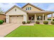 Charming single-Gathering home with an attached garage, front porch and well-manicured landscaping at 14360 W Windrose Dr, Surprise, AZ 85379