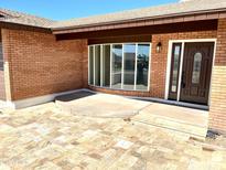 Inviting brick home featuring a beautiful front entrance with a decorative door and a tiled patio at 1440 E Grove Ave, Mesa, AZ 85204