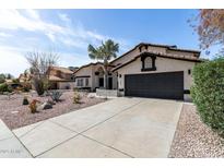 Charming single-story home featuring a desert landscape, a two-car garage, and black trim accents at 14820 N 44Th Pl, Phoenix, AZ 85032